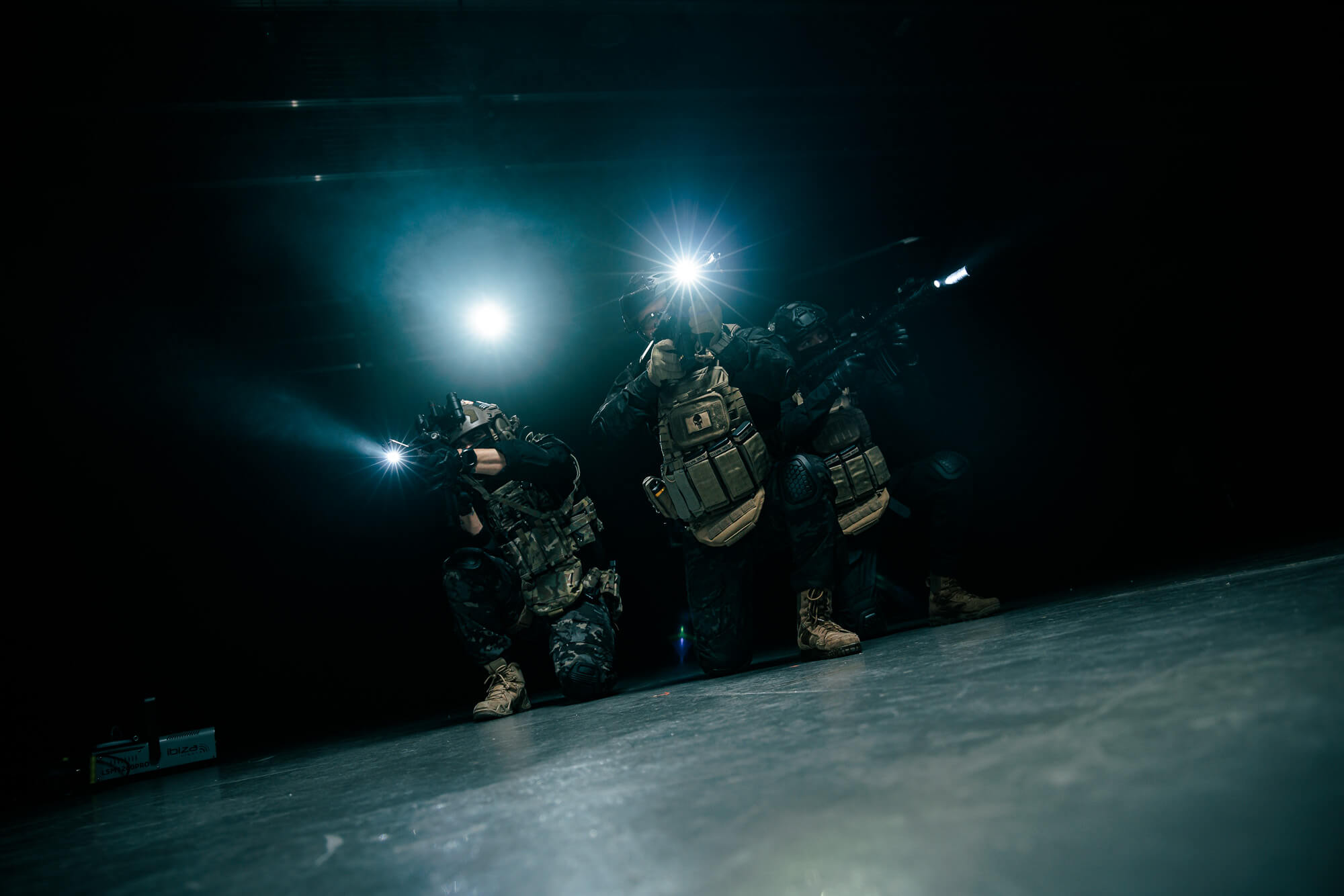 Tres integrantes del Comando 297 avanzan coordinados entre haces de luz